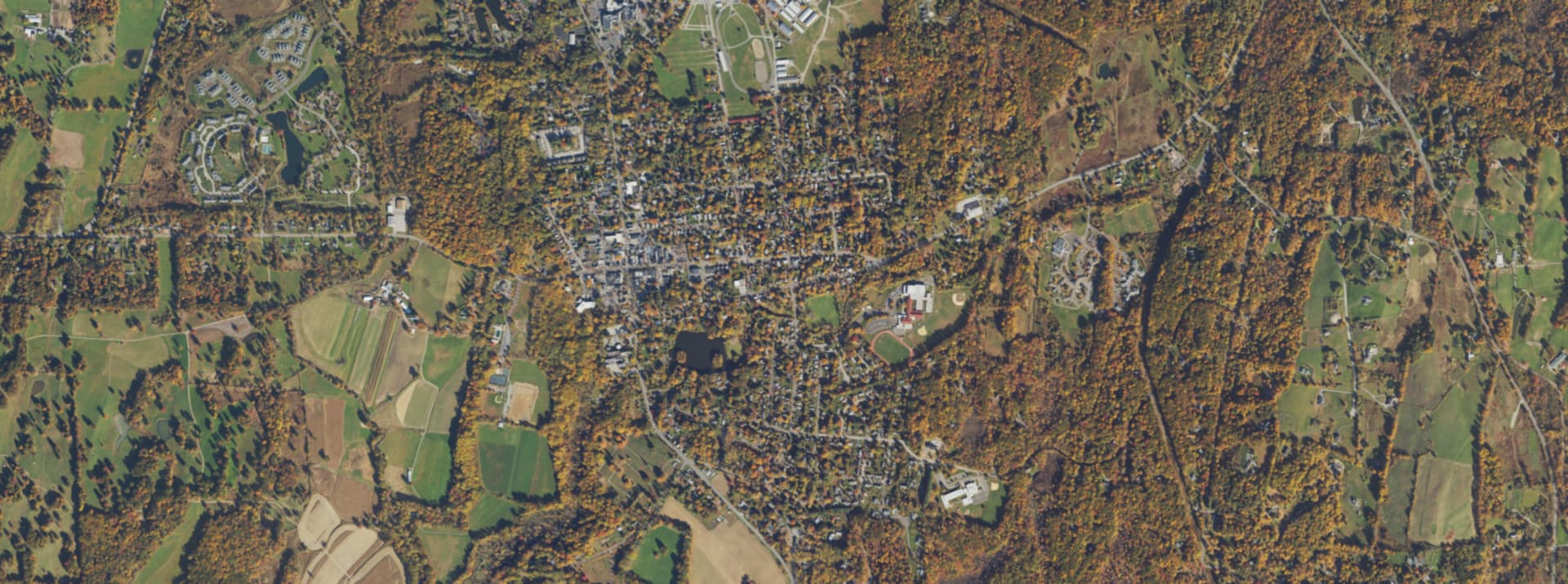 Aerial survey view over Rhinebeck, NY, showing the road network, tree cover and surrounding countryside